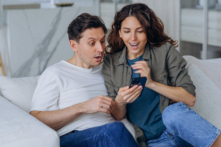 Married woman and man smile happily reading good newsの写真素材