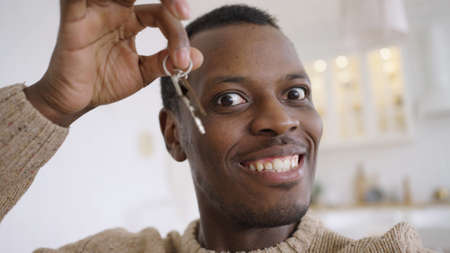 Happy African American man records video showing flat key