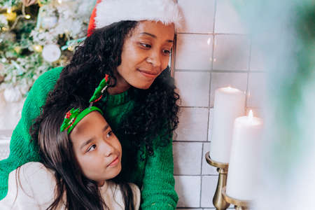Daughter and mother pose with Christmas decorationsの写真素材