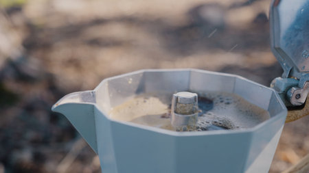 Coffee boils in small kettle on blurry grey backgroundの写真素材