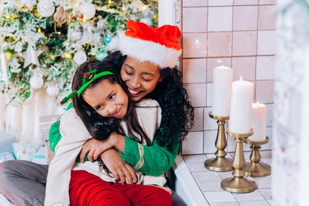 Daughter and mother pose with Christmas decorationsの写真素材