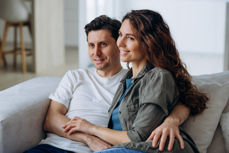 Newlyweds sit on sofa and discuss plans for future dreaming