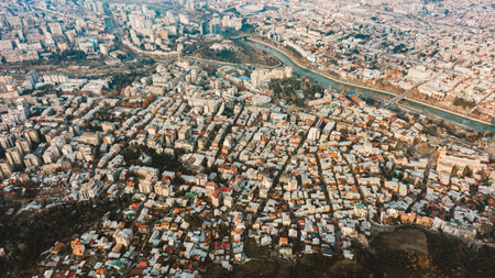 A sprawling urban tapestry, this aerial shot captures the dense clustering of buildings and the serpentine flow of a river through the heart of a bustling city.の写真素材