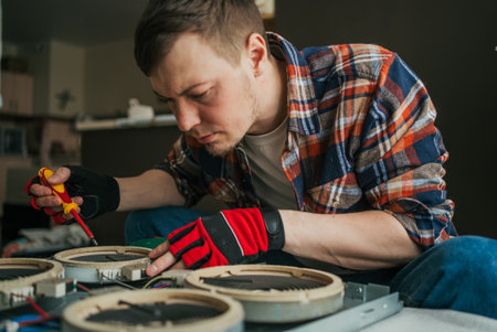 Man Repairing Electronic Device with Screwdriver in a Workshop