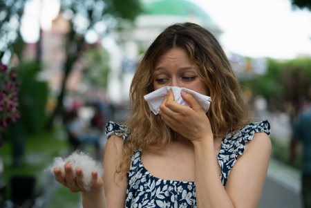 Woman Sneezing and Holding Cottonwood Seeds Outdoors Due to Allergies