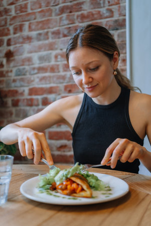 Young Woman Enjoying a Healthy Meal in a Cozy Cafe Setting