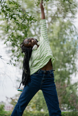 Happy African American woman jumps up, holding out her hand and smiling broadly, has achieved success.の写真素材