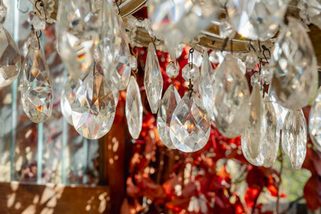 Sunlight dances through the faceted droplets of a crystal chandelier, casting a spectrum of light.の写真素材