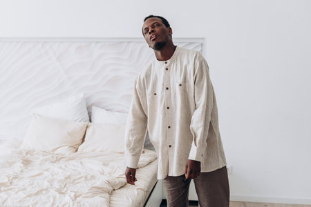 Young black man wearing casual clothing posing in modern bedroomの写真素材