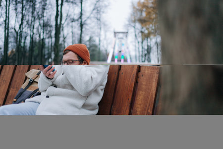 Young man using smartphone in amusement parkの写真素材
