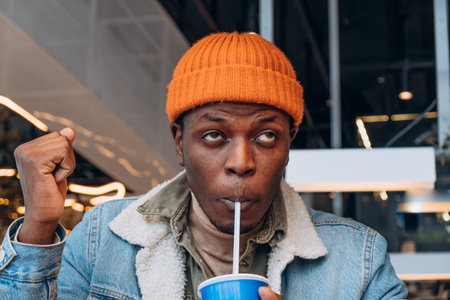Stylish man enjoying a refreshing drink at the food courtの写真素材