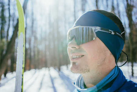 Smiling cross-country skier enjoying winter forest sceneryの写真素材
