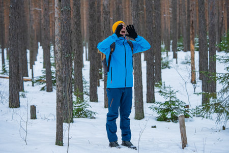 Hiker shouting in snowy forest during winter adventureの写真素材