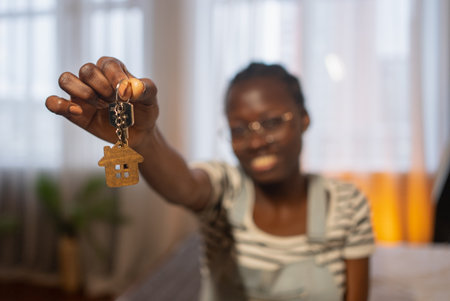 Happy homeowner showing house keys in new propertyの写真素材