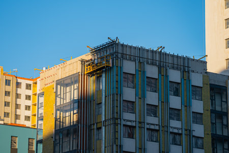 Construction workers installing thermal insulation on building facadeの写真素材