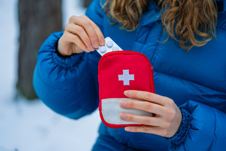Woman taking pills from first aid kit in winter forestの写真素材