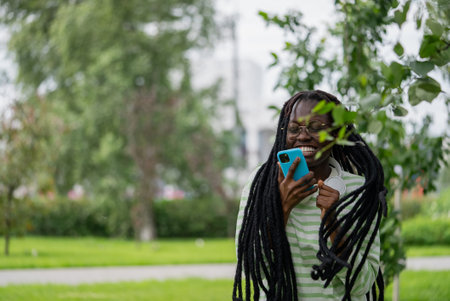 Happy student listening to music on smartphone in parkの写真素材