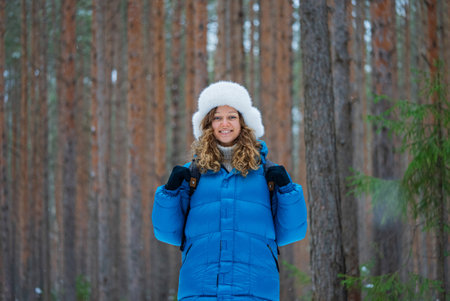 Hiker smiling in snowy forest wearing winter clothesの写真素材