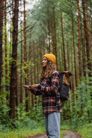 Hiker using smartphone gps app navigating in forest trailの写真素材