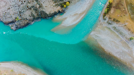 Turquoise river flowing into a lake in a mountain valley landscapeの写真素材