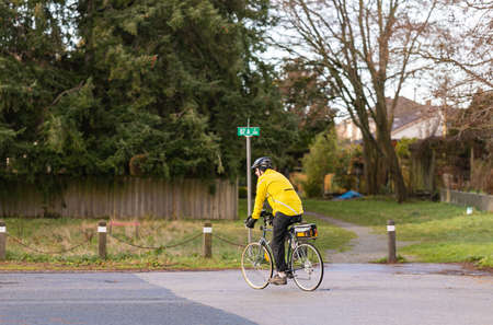 a man in a yellow jacket and helmet riding in the countryside on a bicycle. Street view, travel...