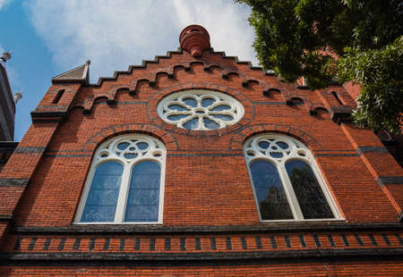 Facade of a historic church with round windows on a brick wall. Victoria BC, Canada. July 23,2021....