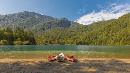 Three colorful canoes or boats on a shore of a lake in a park in beautiful background of the mountains. British Columbia, Canada. Travel photo, nobody, selective focus, concept photo vacationの写真素材