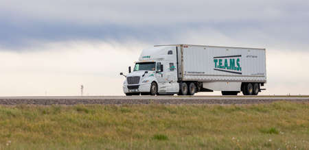 White truck on the highway in a rural area. Street view, travel photo, selective focus, nobody, copy space for text. September 28,2021- Calgary, AB, Canadaのeditorial素材