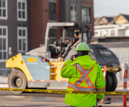 Roadworks signal with worker standing. Traffic control manager watching order on the urban road....