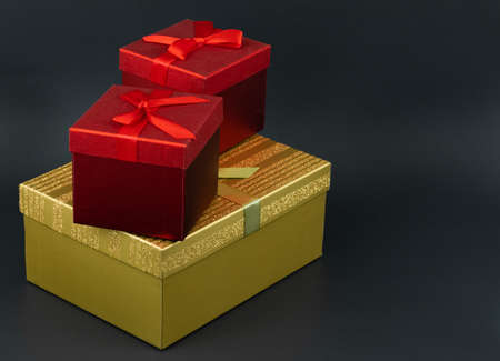 Gift boxes with bowls in the dark background. Elegant gift boxes red and golden color. Shalow depth...