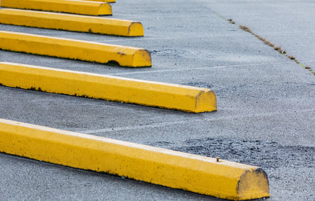Car parking bar in the area close to Shopping Center. Outdoor parking area with yellow concrete bars. Street view, selective focus, nobodyの写真素材