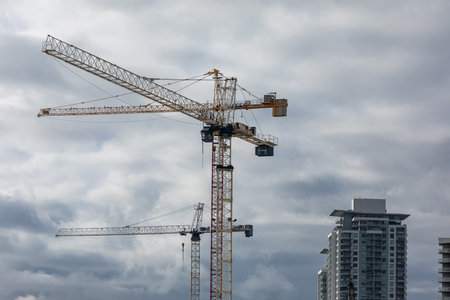 Industrial landscape with constraction cranes on dramatic cloudy sky background. Building constraction site with industrial cranes in New Westminster BC, Canada-December 5,2021. Street view.のeditorial素材