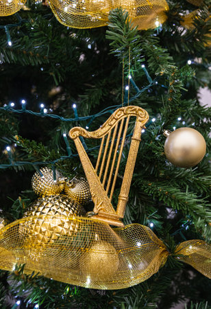 Christmas tree detail with golden christmas bauble. Christmas tree lights and decorations. Selective focus, nobody, street view, concept photo Christmas and Happy New year Holydays.の写真素材