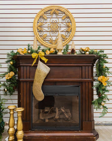 Christmas candles with decoration on a fireplace. Close up of a candle decorated with golden ornamental. Selective focus, blurred background, nobodyの写真素材