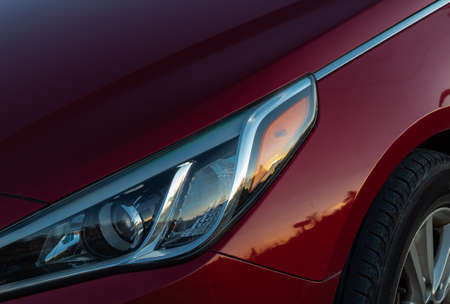Close-up view of red sports car headlight. Headlight lamp of a car, Close up detail on one of the...
