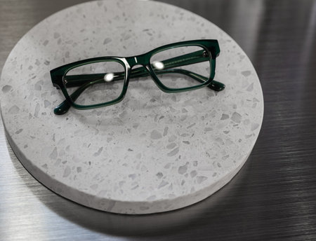 Dark green frame glasses isolated on white background. Reading glasses with dark frames on round white board. Nobody, copy space for text, selective focus.の写真素材