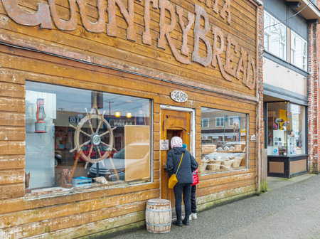 People buy fresh baked rustic bread at the rural bakery. Customers buying traditional bread from local town bakery-December 22,2021-Richmond BC, Canadaのeditorial素材