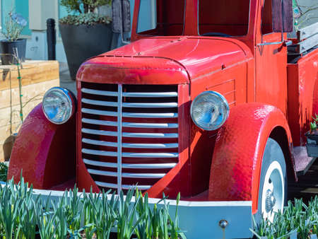 Close up view of the front end of a beautifully restored vintage truck automobile. Old vintage American red pickup car front side. Nobody, street photo, selective focusの写真素材