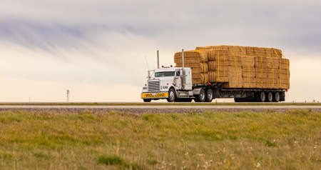 Cargo truck on the highway in a rural area. Street view, travel photo, selective focus, nobody, copy space for text. September 28,2021- Calgary, AB, Canadaのeditorial素材