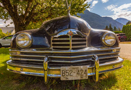 Vintage car Packard close up in a sunny day. Vintage black Packard car in a garden. Hope, BC,...