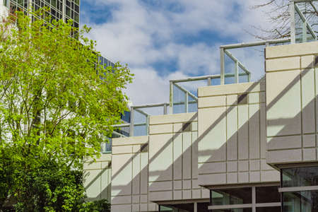 Architecture exterior facade view of modern building wall with lights and shadows. Modern urban architecture is a square shaped building abstract background. Street photo, nobody, selective focusの写真素材