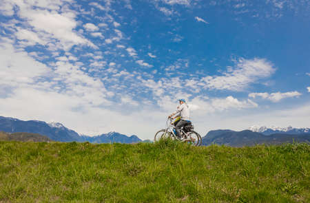 Cyclists ride on the bike path in the Park on a sunny spring day. Senior couple riding bikes-April 24,2022-Vancouver BC, Canada. Street view, travel photo, selective focusのeditorial素材