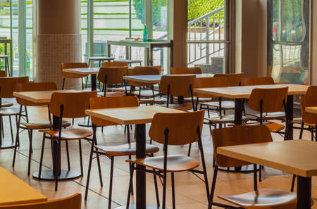 Modern and simple cafe interior with wooden classical furniture. Interior of a small cafeteria. Selective focus, nobodyの写真素材