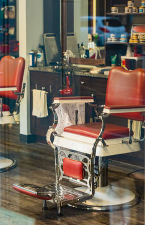 Retro red barber chair through the window of the barber shop.の写真素材