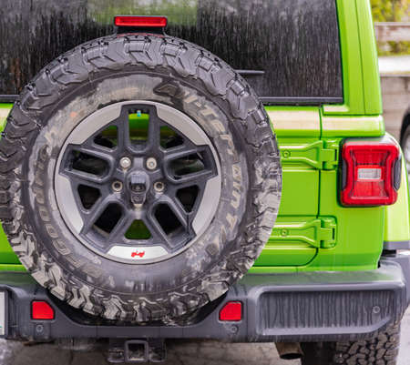 Jeep vehicle on an outdoor parking lot on a rainy day, back view. Spare wheel on the jeep behind-April 26,2022-Vancouver BC Canada. Travel photo, nobody, selective focusのeditorial素材