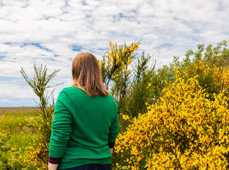 Young caucasian woman looking into the distance in the beautiful spring park. Selective focus, copy space for text.のeditorial素材