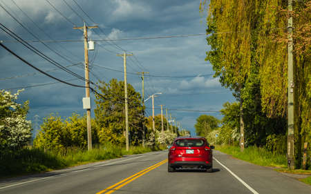Cars moves on a city road on a summer cloudy day in British Columbia Canada. Travel photo, selective...