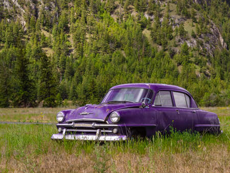 Abandoned rustic car on the hill in summer park in Canada. Vintage old car in the field. Nobody, selective focus, travel photo-June 6,2022-Princenton British Columbiaのeditorial素材
