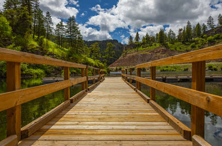 Wooden pier at summer sunny morning. Perspective view of wooden pier at summer lake in Canada. Travel photo, nobody, selective view, copy space for textの写真素材