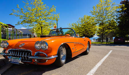 An orange 1959 Chevrolet Corvette Convertible is at summer park. front view. Vintage Chevrolet Corvette a classic cabrio car-June 7,2022-Peachland BC Canada-Travel photo, antique cars conceptのeditorial素材